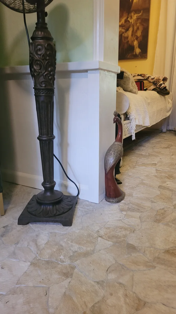 White-painted corner wrap with a projecting trim ledge and base trim above the stone tile floor.
