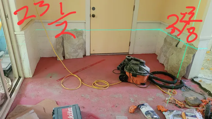 Office work area before finishing, showing the concrete floor, rough lower wall, trim transitions, and original red annotations.