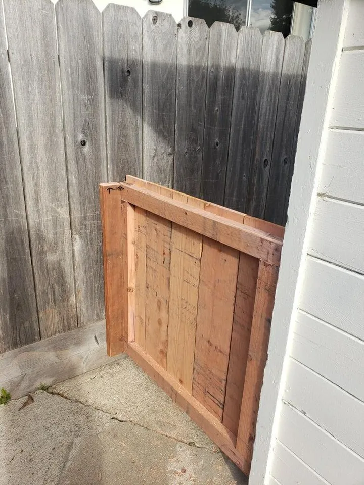 The lightweight gate open from the rear, showing its rectangular timber frame behind the vertical boards.