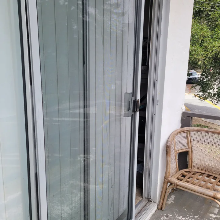 Screen door reinstalled in its doorway, with the screen panel back in place.