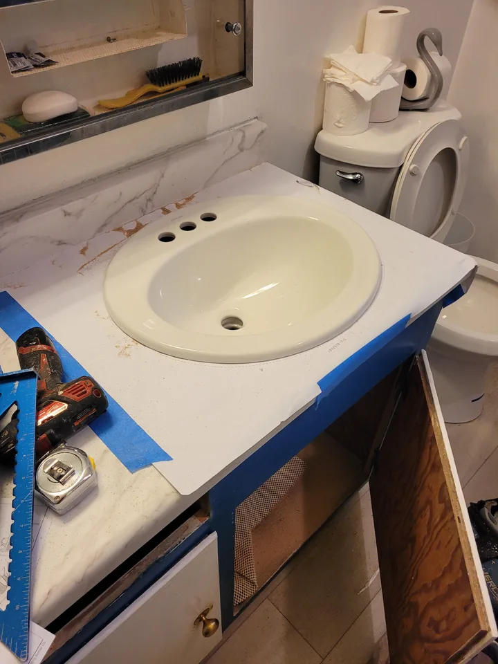 New white oval sink seated in the countertop cutout, with the faucet holes still open.