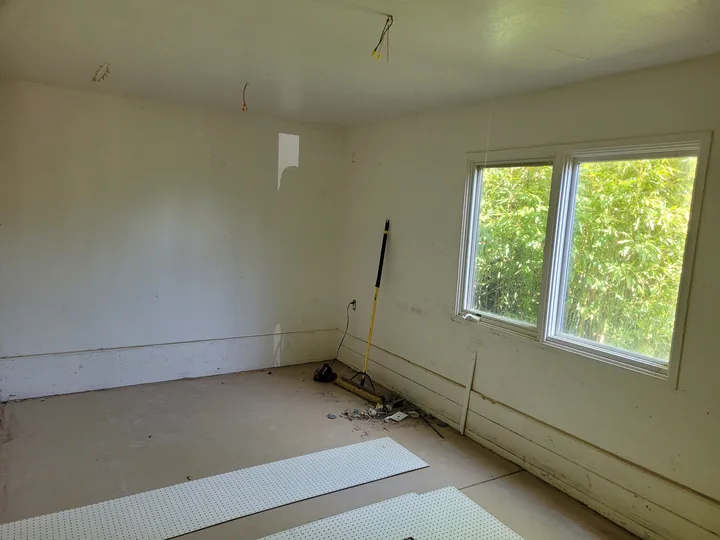 The room before the finishes, with bare flooring and an unfinished lower wall perimeter.